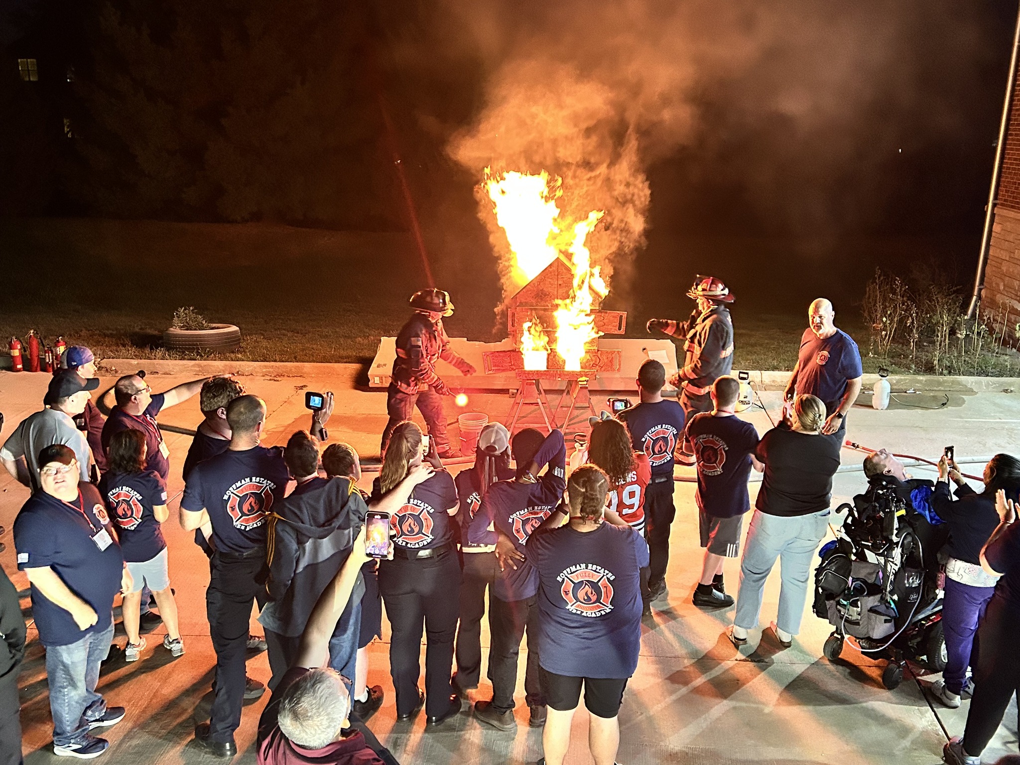 fire academy participants with burning dollhouse